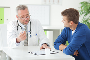 Doctor showing form to male patient at his office.See more LIFESTYLE and MEDICAL images with this COUPLE and DOCTOR or CONSULTANT. Click on image below for lightbox.